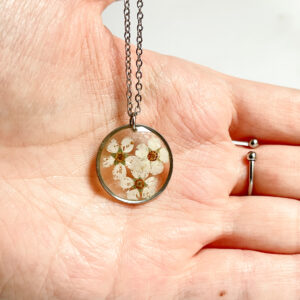 naszyjnik koło z białymi kwiatami