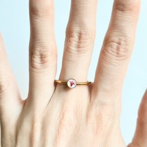 pierścionek - mały, fioletowy kwiatek na białym tle