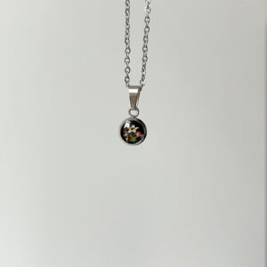 naszyjnik - drobne kółeczko z łąką na czarnym tle