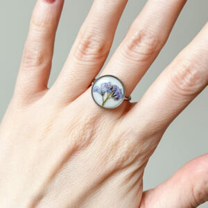 pierścionek - rosnące niezapominajki na białym tle