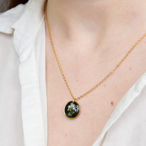 naszyjnik - czarne koło z gałązką białej niezapominajki